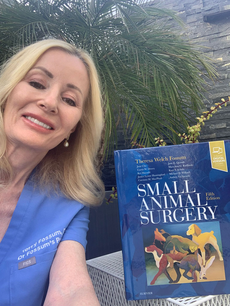 Dr. Terry Fossum holding the fifth edition of Small Animal Surgery